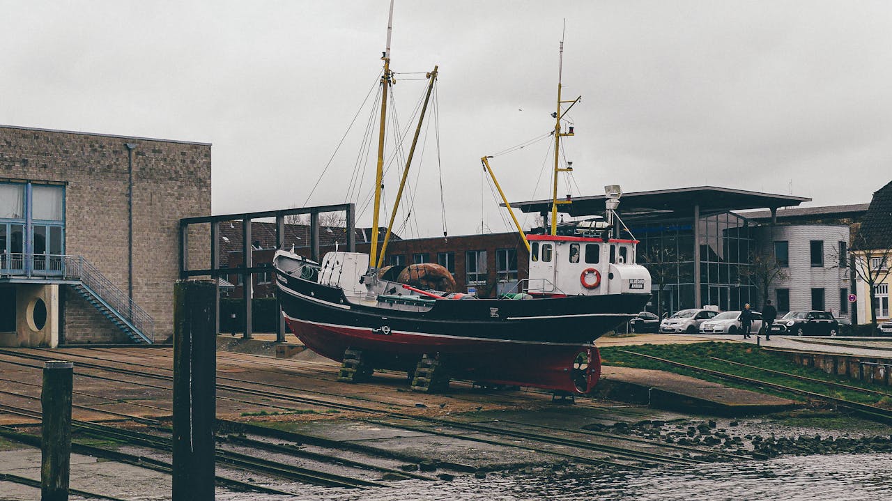 A fishing boat on a dock in Husum, Germany, under a gloomy sky.